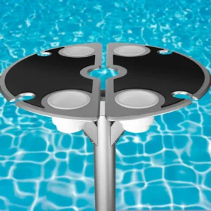Vibrant BajaMate silicone placemats in blue, red, and beige displayed on a 24" aluminum entertainment table, designed to reduce heat and protect surfaces, arranged neatly on a baja shelf with a sparkling pool in the background.