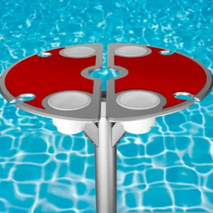 Vibrant BajaMate silicone placemats in blue, red, and beige displayed on a 24" aluminum entertainment table, designed to reduce heat and protect surfaces, arranged neatly on a baja shelf with a sparkling pool in the background.
