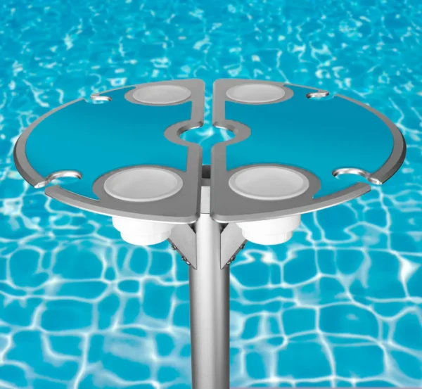 Vibrant BajaMate silicone placemats in blue, red, and beige displayed on a 24" aluminum entertainment table, designed to reduce heat and protect surfaces, arranged neatly on a baja shelf with a sparkling pool in the background.