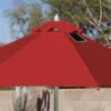 Close-up of a BajaMate Umbrella with a 2" silver aluminum pole and UV-resistant fabric in vibrant blue, showcasing its heavy-duty stainless steel crank mechanism and integrated 20-watt solar panel with a micro USB charging port for poolside use. The red umbrella