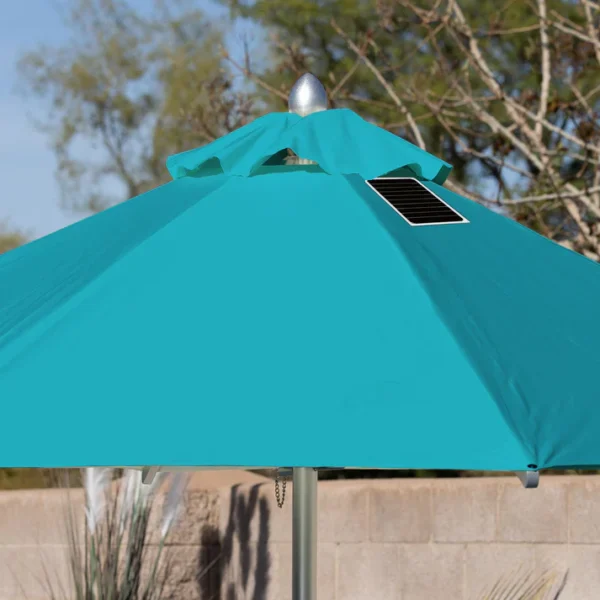 Close-up of a BajaMate Umbrella with a 2" silver aluminum pole and UV-resistant fabric in vibrant blue, showcasing its heavy-duty stainless steel crank mechanism and integrated 20-watt solar panel with a micro USB charging port for poolside use. The Teal umbrella